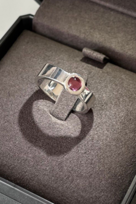 Handcrafted silver ring with red gemstone in elegant jewelry box