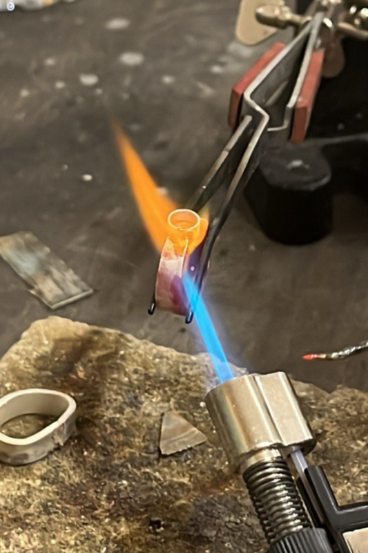 Jewelry soldering process, heating a silver ring with a torch